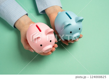 Two piggy banks of different sexes in outstretched hands. Combining household budgets. Merging finances, combining resources, and creating a shared budget in partnerships or family households 124008625