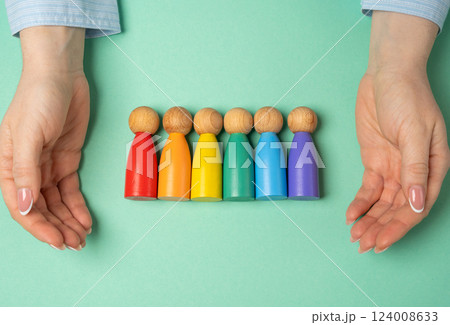 Hands protect the LGBT community made of rainbow colored human figures. Protection, advocacy, and social inclusion. Equality, anti-discrimination efforts, or community support. Hands protect the LGBT community made of rainbow colored human figures. Protection, advocacy, and social inclusion. Equality, anti-discrimination efforts, or community support. 124008633