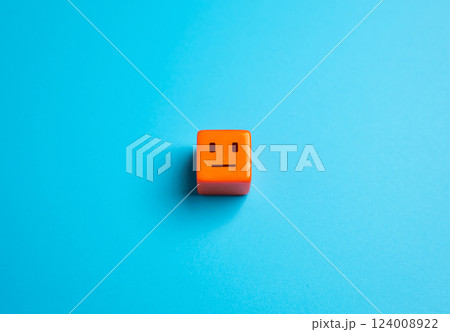 An orange cube with an amorphous, emotionless face. Apathy and indifference. The concept of the average person or consumer. Detachment, monotony and conformity. 124008922