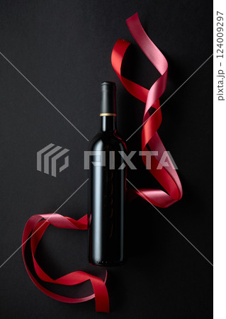 Bottle of red wine with red and pink satin ribbons. Bottle of red wine with red and pink satin ribbons. 124009297
