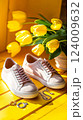 Bright spring vibes with stylish sneakers and cheerful tulips on a sunny yellow backdrop 124009632
