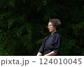 剣道着姿のシニア女性が、屋外で竹刀を持ち、一人稽古をしている 124010045