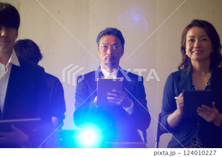 メモを取りながらスライドを見つめるシニア男性 124010227