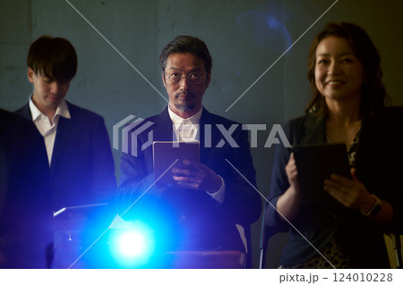 メモを取りながらスライドを見つめるシニア男性 124010228