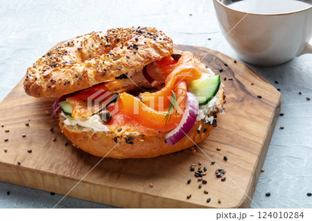 Lox bagel. A sandwich with smoked salmon and fresh vegetables on a plate Lox bagel. A sandwich with smoked salmon and fresh vegetables on a plate 124010284