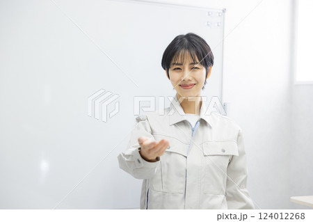 会議室でプレゼンする作業着姿の女性 会議室でプレゼンする作業着姿の女性 124012268