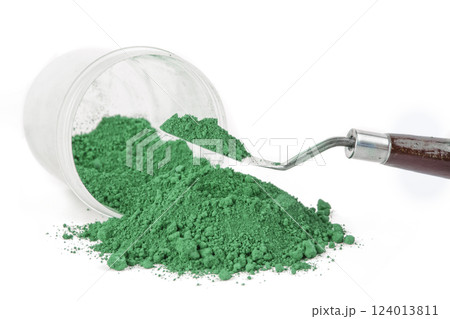 Green Earth, Green Powder Spills From a Jar Onto a Clean Surface With a Scoop Nearby Ready for Use 124013811