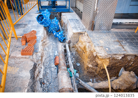 Newly Installed Blue Water Valve Featured in an Urban Construction Site With Exposed Pipes Newly Installed Blue Water Valve Featured in an Urban Construction Site With Exposed Pipes 124013835