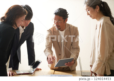 年配のリーダーを中心に打ち合わせをするビジネスパーソン 124014453