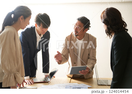 年配のリーダーを中心に打ち合わせをするビジネスパーソン 124014454