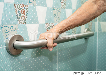 Asian elderly woman patient use handrail safety in toilet support rail in bathroom. Asian elderly woman patient use handrail safety in toilet support rail in bathroom. 124014545