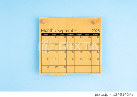 September 2025 brown calendar with wooden thumbtack on blue background. 124014575