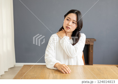 リビングで肩こりを感じる女性01 124014813