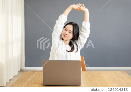 PC前で伸びをするアジア人女性02 124014818