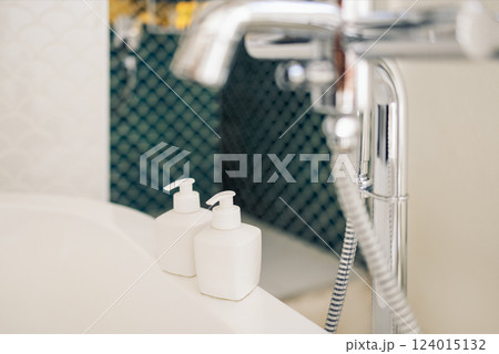 Close-up mockups of cosmetic jars with dispensers on the side of the bathtub 124015132