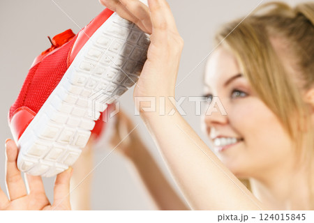 Happy woman presenting sportswear trainers shoes 124015845