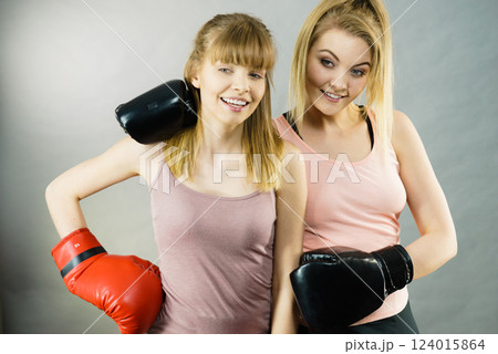 Two women friends wearing boxing gloves Two women friends wearing boxing gloves 124015864