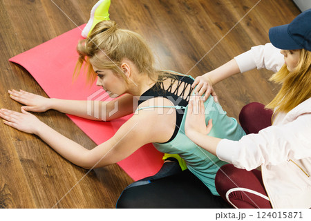 Woman in sportswear doing workout with trainer 124015871