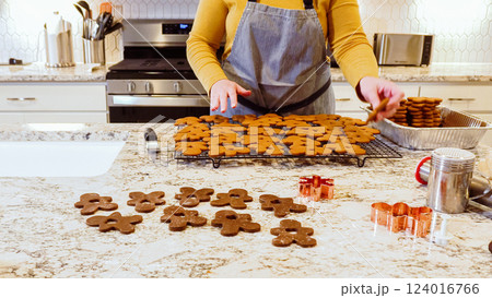 After baking to perfection, these delightful gingerbread cookies are now cooling gracefully on a wire rack, filling the modern kitchen with a warm and inviting aroma. After baking to perfection, these delightful gingerbread cookies are now cooling gracefully on a wire rack, filling the modern kitchen with a warm and inviting aroma. 124016766
