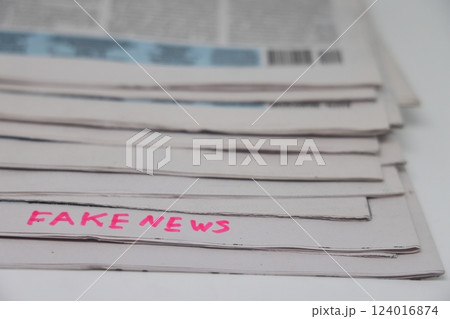A stack of newspapers with the inscription fake news, corrupt journalism. 124016874