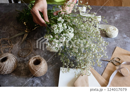 Crafting with natural elements using freshly picked flowers in a creative workspace Crafting with natural elements using freshly picked flowers in a creative workspace 124017079