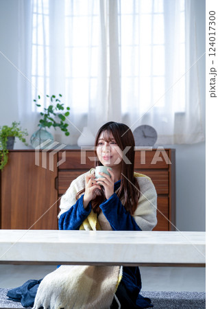 冬のリビングでくつろぐ若い女性 124017300