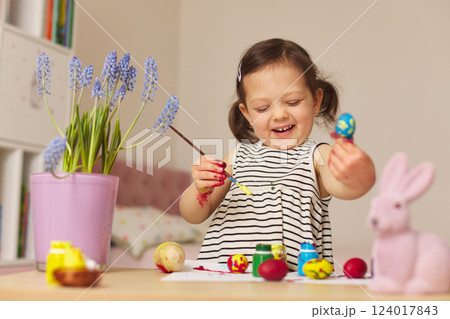 Little child girl showing painted Easter egg at home. kid is preparing for Easter. Little child girl showing painted Easter egg at home. kid is preparing for Easter. 124017843