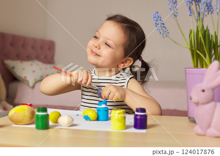 Little child girl paint Easter eggs at home. kid is preparing for Easter. Little child girl paint Easter eggs at home. kid is preparing for Easter. 124017876