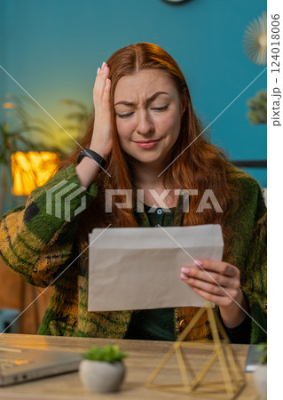 Businesswoman girl opening envelope reading bad news in letter feels upset bankruptcy at home office 124018006