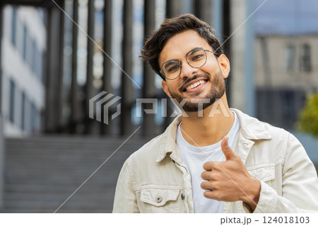 Happy Indian man show thumbs up like sign positive something good positive feedback in city street Happy Indian man show thumbs up like sign positive something good positive feedback in city street 124018103