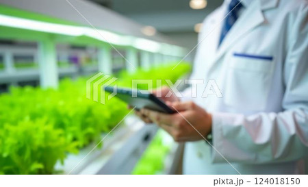 scientist documenting plant growth in controlled greenhouse setting, use of digital tools for modern agriculture, concept of innovative farming and environmental sustainability 124018150