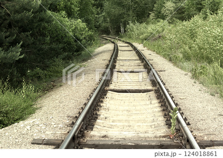 turn of the railway. Steel rails on concrete sleepers disappear from view, going deep into the forest thicket turn of the railway. Steel rails on concrete sleepers disappear from view, going deep into the forest thicket 124018861