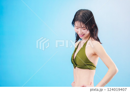 水着を着て夏を満喫する女性（水色背景） 124019407