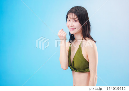 水着を着て夏を満喫する女性（水色背景） 124019412