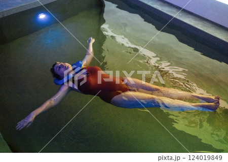 A young woman in a red swimsuit is swimming in the pool. An attractive plump girl enjoys a spa procedure in the salt room. A young woman in a red swimsuit is swimming in the pool. An attractive plump girl enjoys a spa procedure in the salt room. 124019849