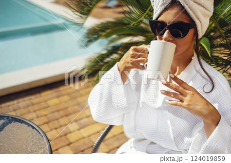 Young pretty woman in a white holds a cup of coffee. 124019859
