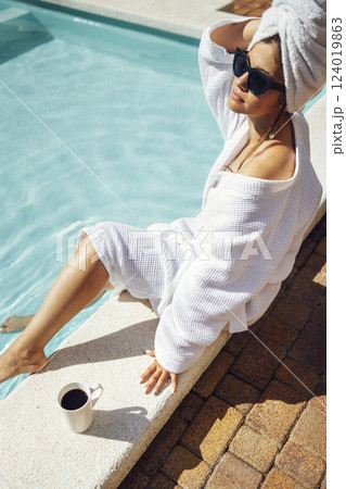 Young pretty woman in a white bathrobe holds a cup of coffee. 124019863