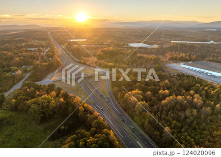 Wide multilane highway crossroads in USA with fast driving cars. Above view of American transportation infrastructure. 124020096