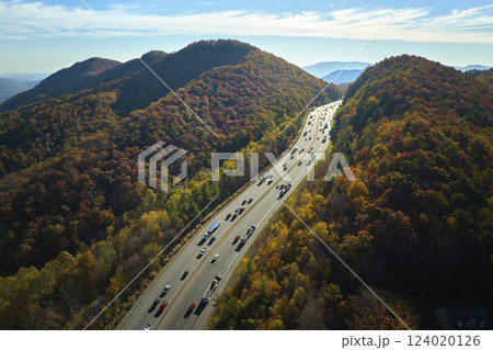 View from above of I-40 freeway in North Carolina heading to Asheville through Appalachian mountains in golden fall season with fast driving trucks and cars. Interstate transportation concept 124020126