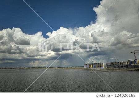 Tower cranes and frame structure of high residential apartment buildings at construction site on sea shore. Real estate development Tower cranes and frame structure of high residential apartment buildings at construction site on sea shore. Real estate development 124020168