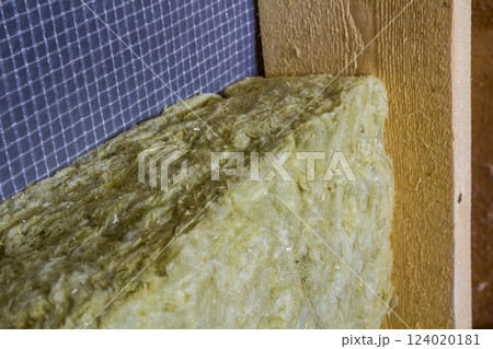 Thermal insulation mineral rock wool installation at the new building attic wall Thermal insulation mineral rock wool installation at the new building attic wall 124020181