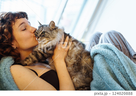 young woman hugging a gray fluffy cat young woman hugging a gray fluffy cat 124020888