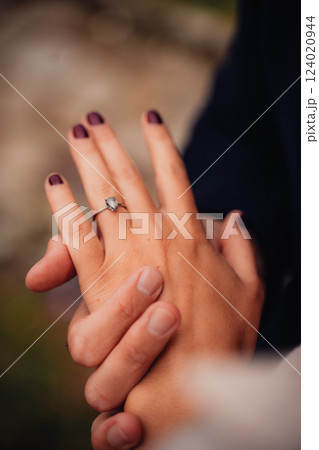 Man places engagement ring on his beloved's hand 124020944