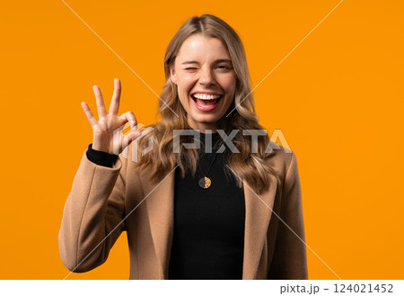 Pretty businesswoman makes hand sign okay, ok gesture. Happy girl, correct perfect choice, great deal, yellow background. Positive female model smiles to camera, approval, trust concept. Pretty businesswoman makes hand sign okay, ok gesture. Happy girl, correct perfect choice, great deal, yellow background. Positive female model smiles to camera, approval, trust concept. 124021452