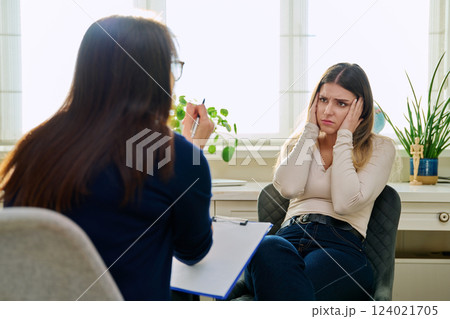 Sad unhappy young woman at therapy with female professional psychologist 124021705