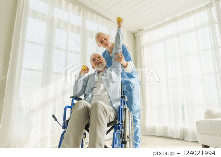 Support rehabilitation healthcare. Nurse helps old man patient in wheelchair picking up dumbbells. Paralyzed man in chair for people with disability doing sports exercise with nurse. Medical caregiver Support rehabilitation healthcare. Nurse helps old man patient in wheelchair picking up dumbbells. Paralyzed man in chair for people with disability doing sports exercise with nurse. Medical caregiver 124021994