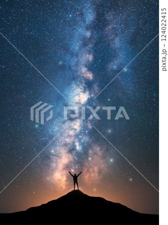 Milky Way and happy man on the mountain peak at starry night 124022415