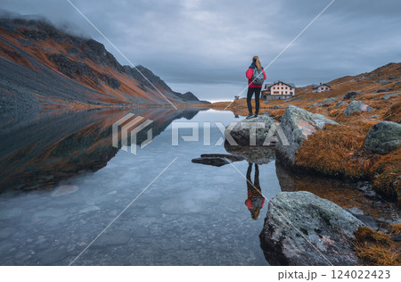 Young woman standing on a rock on alpine mountain lake. Young woman standing on a rock on alpine mountain lake. 124022423