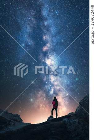 Milky Way and woman on mountain peak at starry night. Vertical 124022449