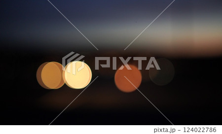 Blurred lights evening city traffic bokeh. Defocused night city traffic. Blurred lights bokeh car headlights driving evening city road. City night traffic background 124022786